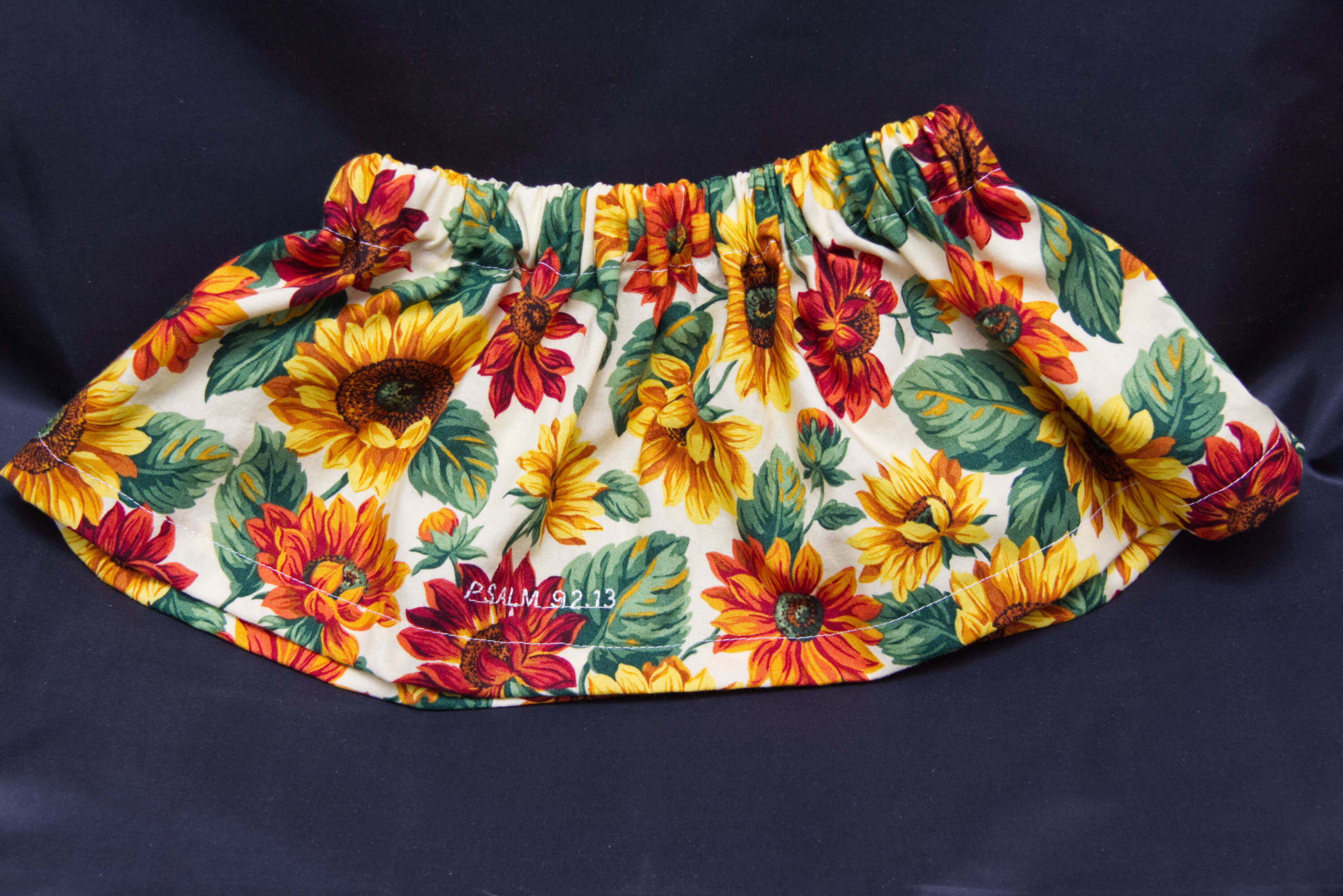 A cream skirt with yellow and red marigolds on it.